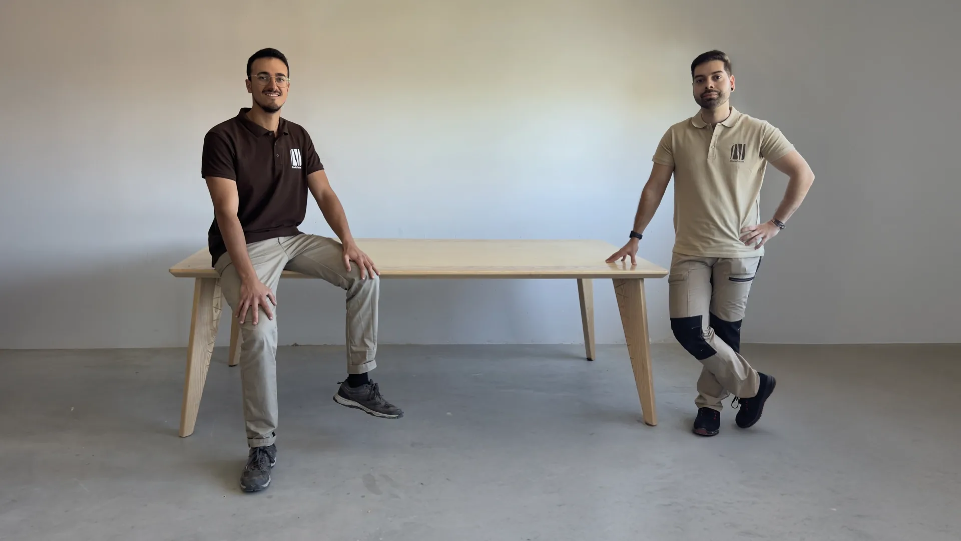 Mario Sierra y Álvaro Rodríguez, socios de Studio Tablas, junto a una mesa de madera maciza en el taller